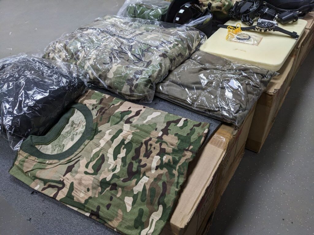 An image showing military clothing issued to new Wagner Group recruits at the Molkino training center in Krasnodar. The clothing consists of camouflage uniforms, boots, and protective gear.