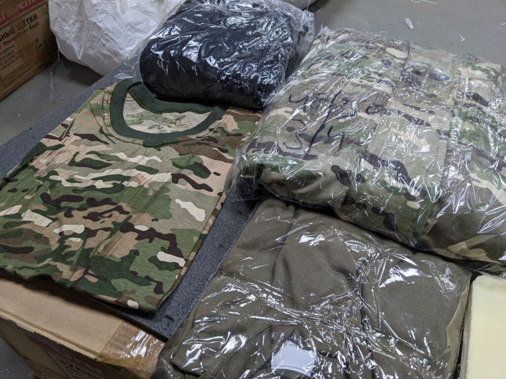 An image showing military clothing issued to new Wagner Group recruits at the Molkino training center in Krasnodar. The clothing consists of camouflage uniforms, boots, and protective gear.